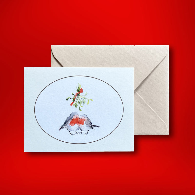 these two robins flirt under the mistletoe on the front of this landscape folded christmas card. Supplied with plain cream envelopes in our branded box.