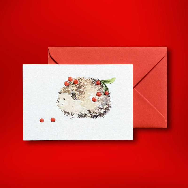 Decorated with his mistletoe berries, the hedgehog is painted on the front cover of this landscape folded christmas card. Painted by Katherine Yan for Pemberly Fox they are supplied with bright red C6 envelopes in our branded box.